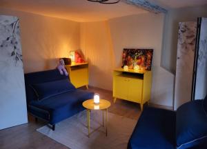 salon z niebieską kanapą i stołem w obiekcie L'Arsouille Gîte Rural Doische w mieście Doische