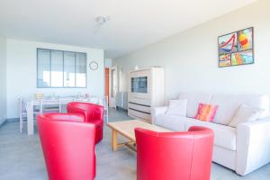 a living room with red chairs and a white couch at Appartement une chambre avec vue sur la baie des Sables 4 personnes in Les Sables-dʼOlonne