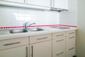 a kitchen with a sink and red tiles at Appartement une chambre avec vue sur la baie des Sables 4 personnes in Les Sables-dʼOlonne