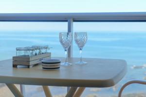 two wine glasses on a table in front of a window at Appartement une chambre avec vue sur la baie des Sables 4 personnes in Les Sables-dʼOlonne
