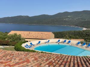une piscine avec des chaises et un plan d'eau dans l'établissement T2 Alba Rossa n 141 Confort, Panorama Mer Incroyable, à Serra-di-Ferro