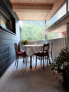 une terrasse couverte avec une table et des chaises. dans l'établissement Chalet Vacanza, à Brand