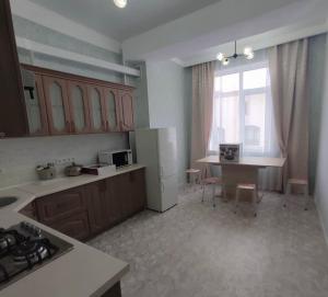 a kitchen with a counter and a table in it at Polaris plus in Bishkek