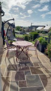 einen Tisch und zwei Stühle auf einer Terrasse in der Unterkunft Studio calme in Pleine-Fougères