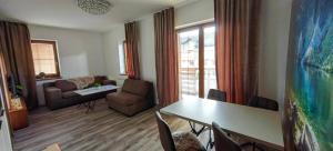 a living room with a couch and a table and chairs at Apartment FIMM in Veľká Lomnica