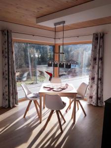 uma sala de jantar com uma mesa e cadeiras e uma janela em Chalet Vacanza em Brand