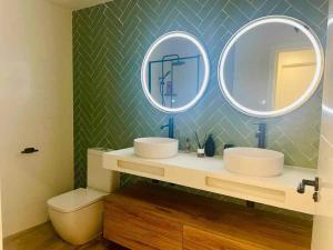 a bathroom with two sinks and two mirrors at Casa Carmela in Fuenmayor +14 photos