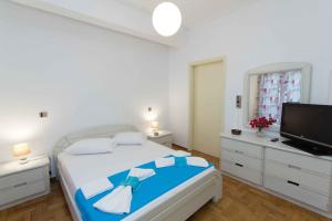 a bedroom with a large bed and a flat screen tv at Paros Hospitality by the sea in Kampos Paros