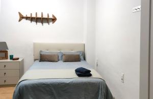 um pequeno quarto com uma cama com lençóis azuis em KOA Centric, comfy in Ruzafa em Valência