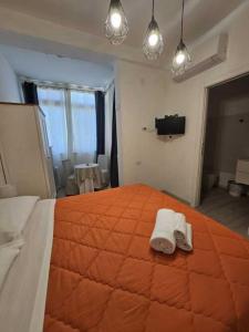 1 dormitorio con 1 cama grande y 2 toallas. en Guest House Aio Sardegna, en Cagliari