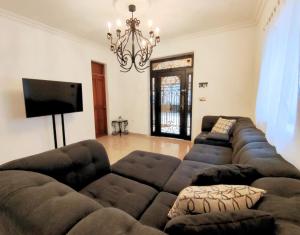 a living room with a couch and a flat screen tv at Colonial Villa in Merida Centro 4BR 3BA Private Pool Near Paseo de Montejo in Mérida