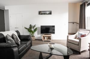 a living room with a couch and a tv at Hagley park Hidden Gem in Christchurch