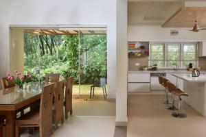 a kitchen and dining room with a table and chairs at Premium 5 BR full pool villa by lake close to Vagamon in Muttam