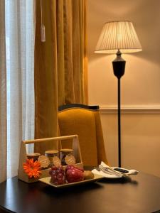 ein Tablett mit Essen auf einem Tisch neben einer Lampe in der Unterkunft Peerless Hotel Kolkata in Kalkutta