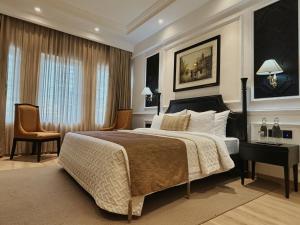 1 dormitorio con cama, escritorio y silla en Peerless Hotel Kolkata en Calcuta
