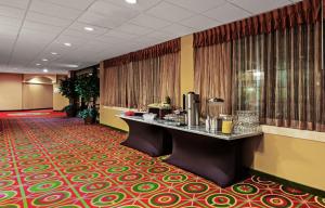 Holiday Inn Hotel & Suites Springfield, an IHG Hotel في سبرينغفيلد: لوبي الفندق مع مكتب استقبال وسجادة حمراء