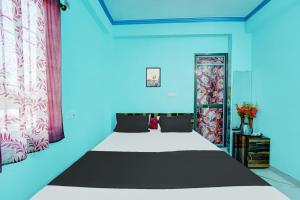 Habitación azul con cama y puerta con cortinas en OYO Flagship R K Marriage Hall and Guest House en Bihta