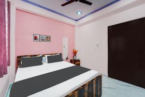 1 dormitorio con cama y pared de color rosa en OYO Flagship R K Marriage Hall and Guest House en Bihta