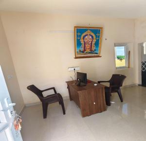 a office with a desk and two chairs and a computer at Arumugam Residency AC in Thiruchendur