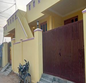 a bike parked in front of a house at Arumugam Residency AC in Thiruchendur