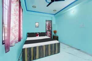 ein Schlafzimmer mit einem Bett in einem Zimmer mit blauen Wänden in der Unterkunft OYO Flagship R K Marriage Hall and Guest House in Bihta