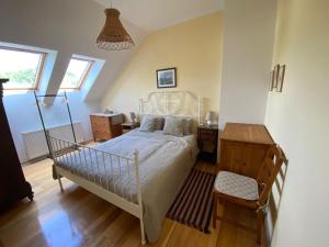 Schlafzimmer mit einem weißen Bett und Holzboden in der Unterkunft Na Husovce in Teplice