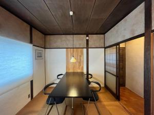 una sala da pranzo con tavolo e sedie neri di AKUNOURA HUIS - Vacation STAY 10922 a Nagasaki