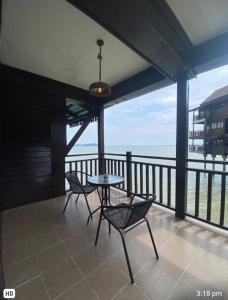 a patio with two chairs and a table on a balcony at The Green Lagoon in Pantai Cenang