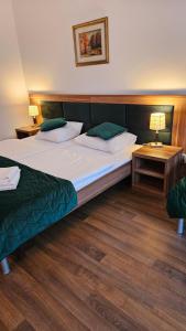 a hotel room with two beds and two tables at Bursztyn Resort in Kołobrzeg