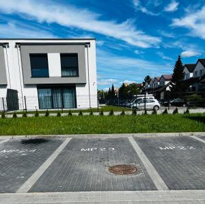 een parkeerplaats voor een wit gebouw bij Apartament Nowa Grunwaldzka in Suwałki