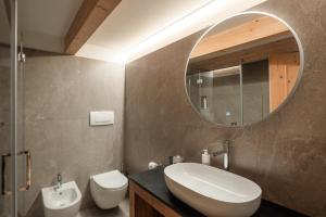 ein Bad mit einem Waschbecken und einem Spiegel in der Unterkunft Hotel Bellavista in Cavalese