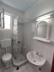 a bathroom with a toilet and a sink at Cosmos Studios in Olympic Beach +20 photos
