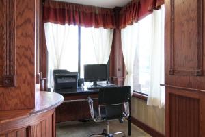 a desk with a chair and a window at Baymont by Wyndham Muskegon in Muskegon