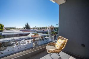 a balcony with a chair and a view of a building at 3K Rodo Rooms in Faliraki