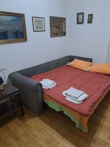 ein Bett in einem Zimmer mit einer roten Decke darauf in der Unterkunft Kostas' House luxury apartment near Volos center in Volos