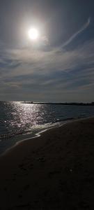 uma praia com o sol brilhando sobre a água em Attico Centrale Ostia 20 em Lido di Ostia