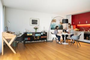 eine Gruppe von Menschen, die an einem Tisch in einer Küche sitzen in der Unterkunft Senevita Residenz & Apartments Muri bei Bern in Bern