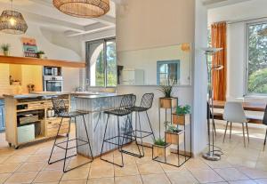 a kitchen with a bar with stools in it at Domaine du Peymian-Villa Art Deco in La Ciotat