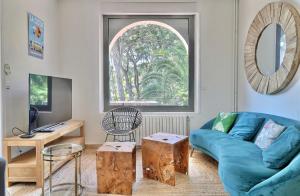 拉西約塔的住宿－Domaine du Peymian-Villa Art Deco，客厅设有蓝色的沙发和窗户。
