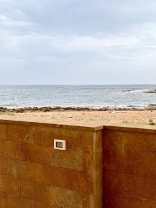 uma parede de tijolos ao lado de uma praia com o oceano em Lulù Sole-Relax em Calabernardo