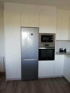 eine Küche mit Kühlschrank und Mikrowelle in der Unterkunft Espectaculares vistas a la Ría de Aldán in Bueu