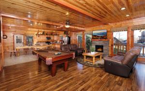 a living room with a pool table in a cabin at Splash N Mountain Lookout in Pigeon Forge