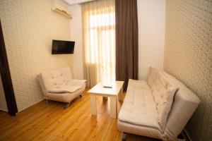 sala de estar con sofá, silla y mesa en IRISE en Batumi