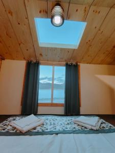 a bedroom with a bed with a window and a light at The Grand Lodge Pangong in Lukung