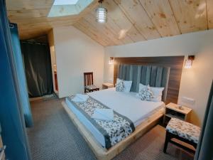 a bedroom with a large bed and a wooden ceiling at The Grand Lodge Pangong in Lukung