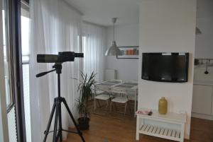 a camera tripod in a living room with a television on a wall at Apartament Panorama in Tczew