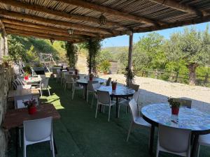 eine Reihe von Tischen und Stühlen unter einer Pergola in der Unterkunft Dimora dei Cardinali in Agropoli