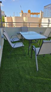 een tafel en stoelen op een dak met gras bij Karma Athens in Athene
