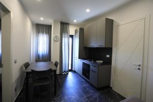uma pequena cozinha com uma mesa e uma sala de jantar em Residenza Arena em Tropea