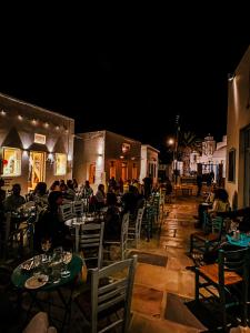 eine Gruppe von Menschen, die nachts an Tischen in einem Restaurant sitzen in der Unterkunft Stunning town-house in Chora, Serifos in Serifos Chora